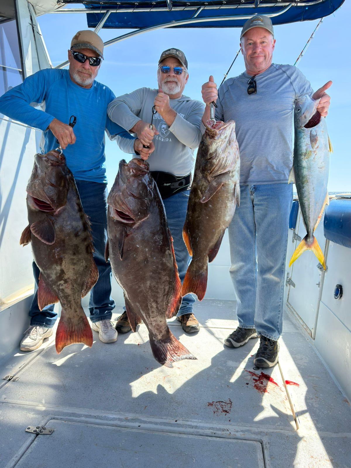 Three anglers displaying trophy grouper and yellowtail on WanderLust